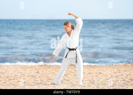 Giovane donna a praticare il karate all'aperto Foto Stock