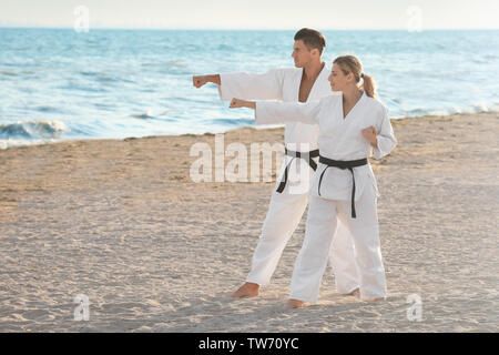 Giovane uomo e donna a praticare il karate all'aperto Foto Stock
