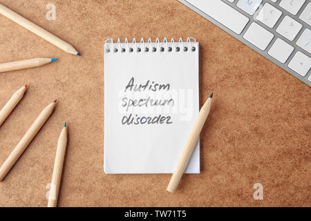 Parole "Autismo disordine di spettro' scritta in notebook sul tavolo Foto Stock