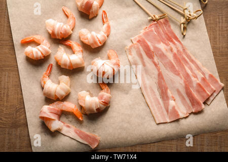 Materie di gamberetti e pancetta sul tavolo di legno Foto Stock