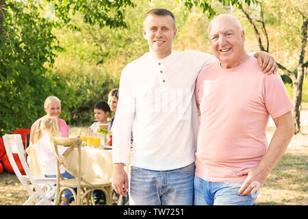 La famiglia felice avente il barbecue all'aperto Foto Stock