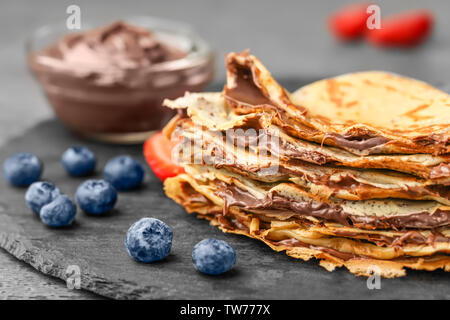 Piastra con thin pancake con impasto di cioccolato e frutti di bosco sul  tavolo Foto stock - Alamy