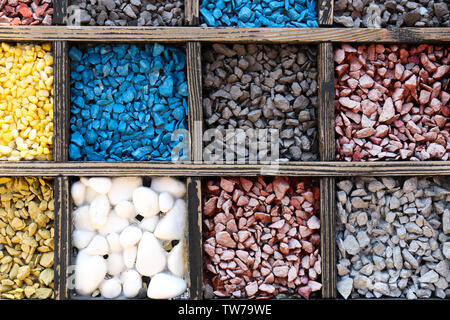 Molti colori diversi pietre in scatole di legno come sfondo Foto Stock