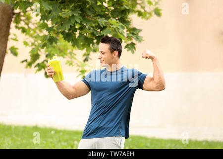 Bel giovane con protein shake all'aperto Foto Stock