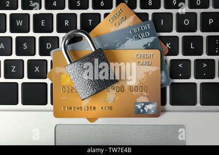 Carte di credito e bloccare sulla tastiera del notebook, close up Foto Stock