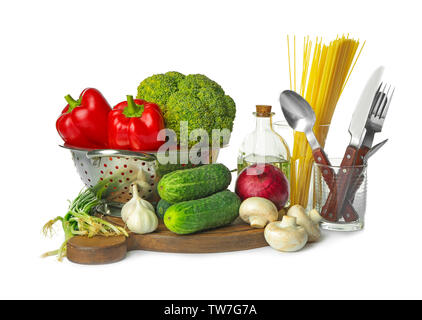 Composizione con diversi ortaggi e utensili di cottura su sfondo bianco Foto Stock