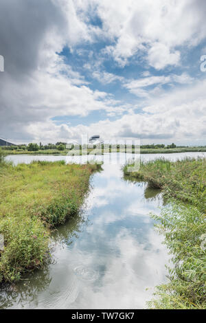 Lakeside costruzione spazio verde traliccio sotto le nuvole Foto Stock