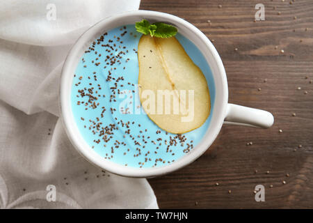 Piatto con yummy spirulina smoothie su un tavolo di legno. Vegano sano concetto alimentare Foto Stock