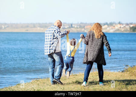 Il sovrappeso giovane con il figlio a piedi vicino al fiume sulla giornata di sole Foto Stock