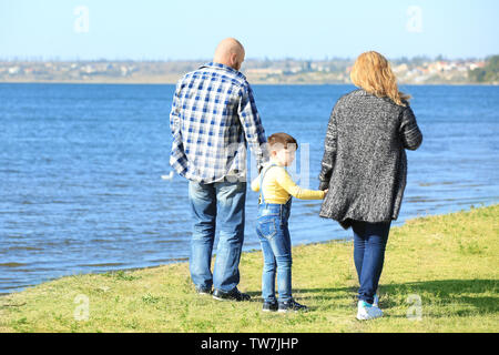 Il sovrappeso giovane con il figlio a piedi vicino al fiume sulla giornata di sole Foto Stock