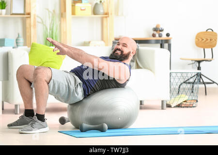 Il sovrappeso uomo a fare gli esercizi a casa Foto Stock