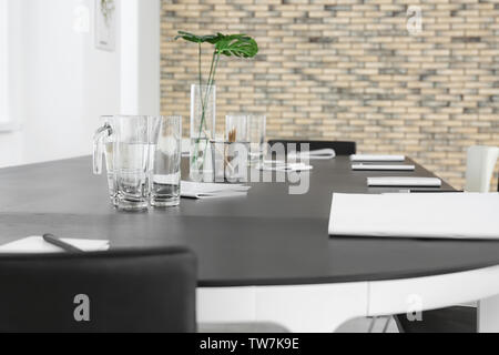 Bicchieri e brocca con acqua sul tavolo per ufficio Foto Stock