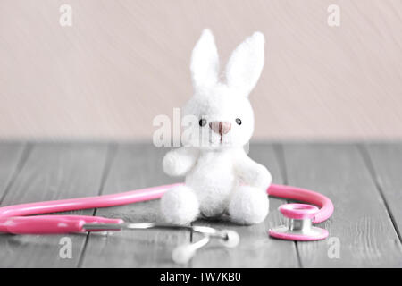 Toy bunny e uno stetoscopio sul tavolo. Concetto di pediatra Foto Stock