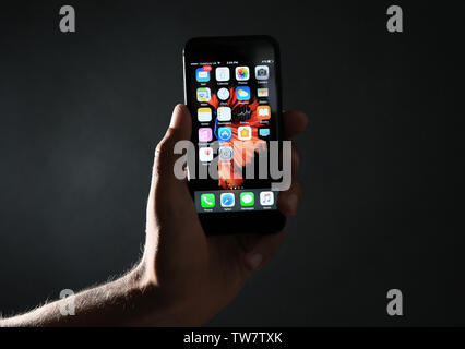 KIEV, UCRAINA - Ottobre 06, 2017: uomo tenendo iPhone nero 7 con la schermata iniziale contro uno sfondo scuro Foto Stock