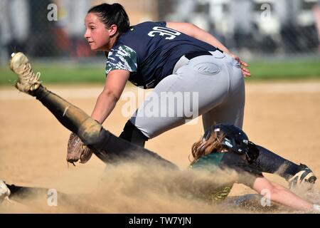 Dopo aver preso un tiro del catcher, un terzo baseman non è stato in grado di impedire che un avversario runner dal furto di terza. Stati Uniti d'America. Foto Stock