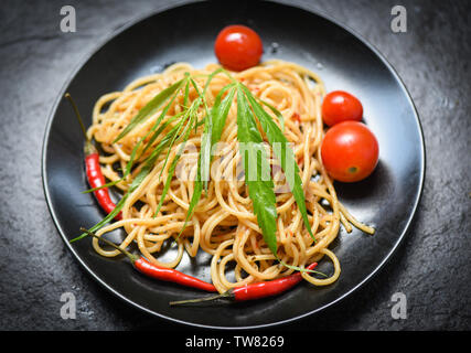 La Cannabis cibo con gli spaghetti al pomodoro e il peperoncino e le foglie di basilico verdure / tradizionale delizioso cibo italiano a foglia di marijuana sulla parte superiore Foto Stock