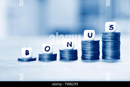 Bonus annuale concetto / parole di bonus sulla pila di monete scala per incoraggiamento morale sulla tabella office company Foto Stock