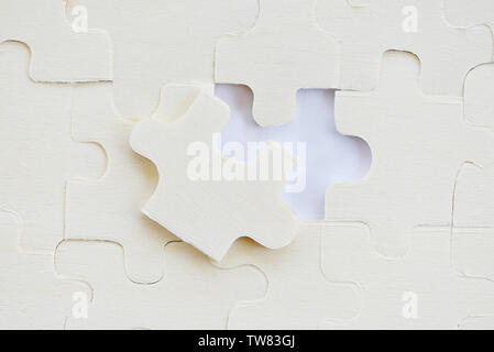 Puzzle rompicapo su bianco /Jigsaw pezzi sullo sfondo di texture Foto Stock