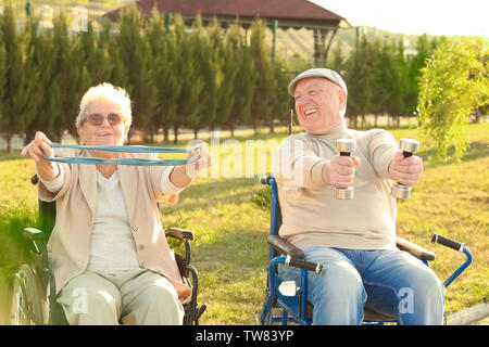 Senior l uomo e la donna dalla casa di cura facendo esercizio all'aperto Foto Stock