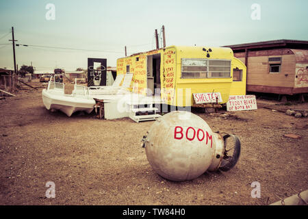 Prese a Bombay beach in Salton Sea area. Barca abbandonata e il rimorchio in un post-apocalittico paesaggio. Foto Stock