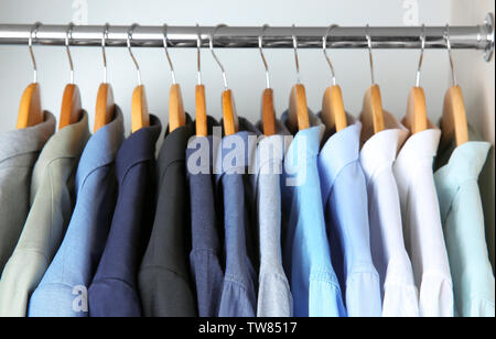 Maschio di giacche e camicie appeso sulla rampa di capi di abbigliamento in armadio Foto Stock