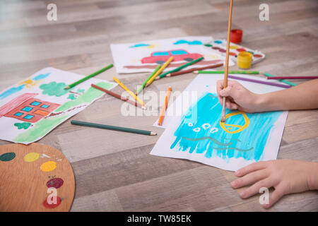 Bambina dipinto con acquerelli sul pavimento Foto Stock