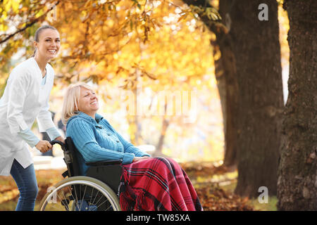 Disabili donna senior e giovani infermiere in posizione di parcheggio Foto Stock