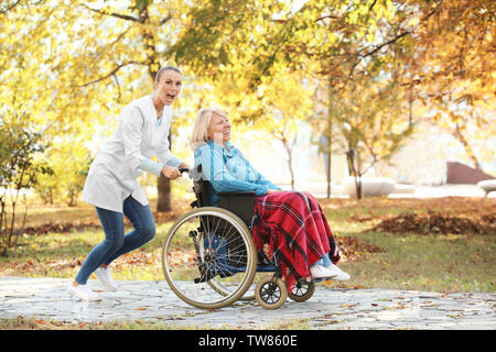 Disabili donna senior e giovani infermiere in posizione di parcheggio Foto Stock