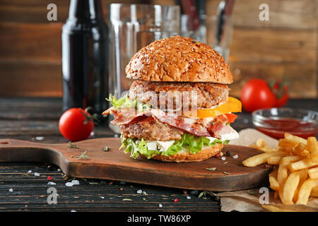 Scheda con gustosi double burger sul tavolo di legno Foto Stock