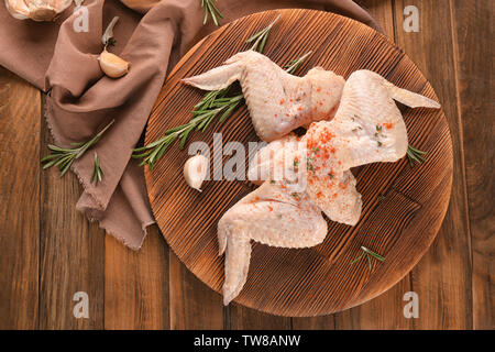 Tavola di legno con materie di ali di pollo su tavola Foto Stock