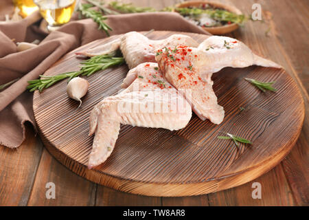 Tavola di legno con materie di ali di pollo su tavola Foto Stock