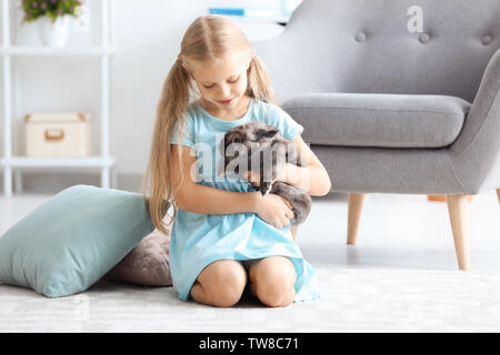 Bambina con coniglio adorabili in ambienti interni Foto Stock