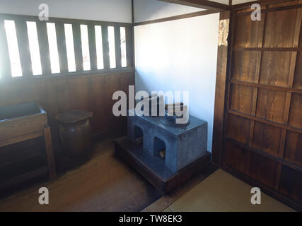 Angolo cottura nel tradizionale giapponese del periodo Edo edificio storico interno. Stufa in una piccola illuminata con luce solare cucina di Takayama Jinya house, Takayam Foto Stock