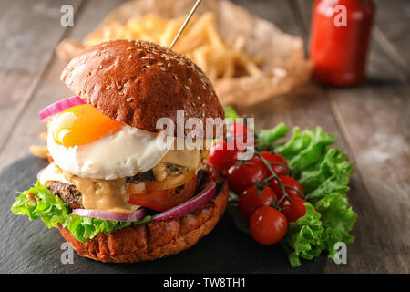 Gustosa burger con uovo fritto sulla piastra di ardesia Foto Stock