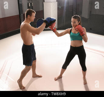 Giovani femmine boxer formazione in palestra con personal trainer Foto Stock