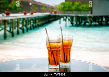 Tè freddo contro tropical Overwater Bungalow Resort sulla spiaggia, Maldive. Foto Stock