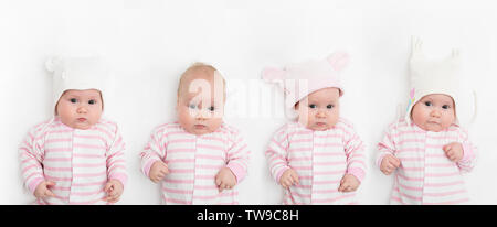 Carino adorabile figlio bambino con differenti bianco caldo e rosa cappelli. Happy Baby girl su sfondo bianco e guardando la telecamera. Foto Stock