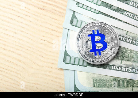 Bitcoin in argento con le fatture del dollaro sul tavolo Foto Stock