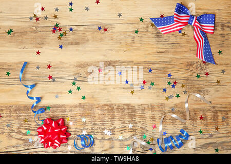 Bandiera americana di prua e coriandoli su sfondo di legno. Stati Uniti d'America holiday Foto Stock