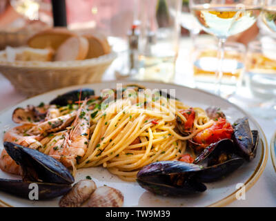 Spaghetti allo scoglio o spaghetti con frutti di mare servita in un piatto bianco con gamberetti e altre conchiglie Foto Stock