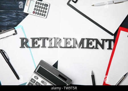 La parola "pensionamento' cartelline e calcolatrice sul tavolo. Pianificazione previdenziale Foto Stock