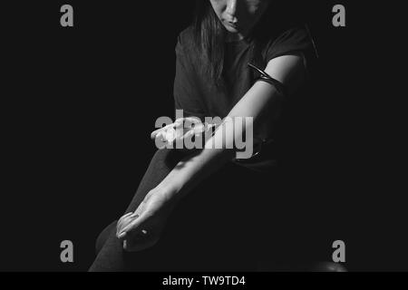 Tossicodipendente donna uso siringa iniettare farmaci nel suo braccio. farmaci addict concept Foto Stock