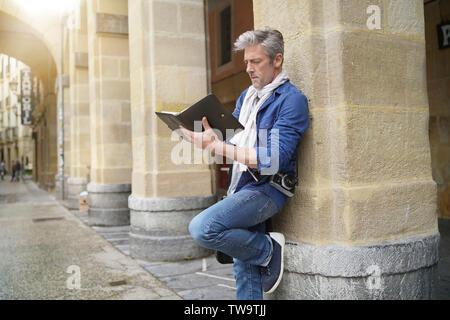 Artista matura delineando in Centro storico Foto Stock