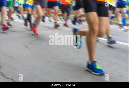 Sfocato sfondo sport - persone a piedi in esecuzione su una strada asfaltata durante la prima maratona olimpica Foto Stock