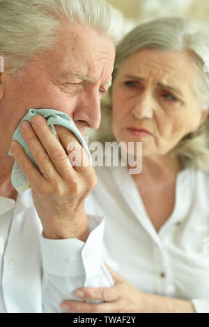 Triste Coppia senior, man tenendo la mano sulla guancia con il mal di denti Foto Stock