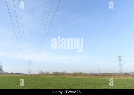 Linee di alimentazione aeree e tralicci di energia elettrica sulla rete nazionale nel Buckinghamshire, UK. Ampia area di cielo con copia spazio. Foto Stock