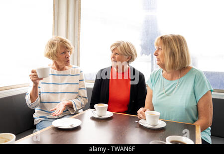 Gioiosa amici anziani avente un tè o un caffè insieme. Senior amiche in chat di ridere e di divertirsi nel coffee shop a rimanere attivi in pensione Foto Stock