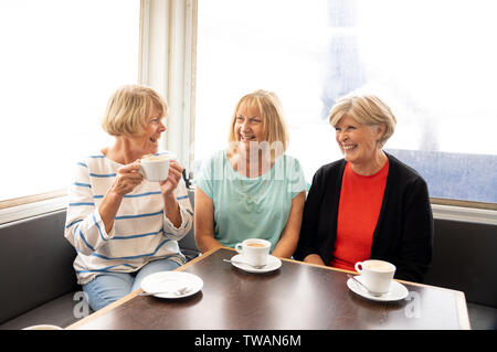 Gioiosa amici anziani avente un tè o un caffè insieme. Senior amiche in chat di ridere e di divertirsi nel coffee shop a rimanere attivi in pensione Foto Stock