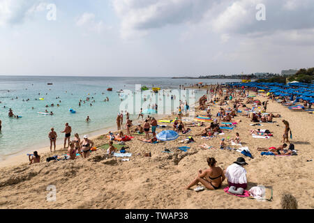 Spiaggia con turisti rilassante sulla spiaggia, piscina e giochi su un caldo giorno d'estate. Ottobre 20, 2019. Aya Napa Cipro. Foto Stock