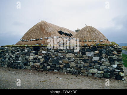 Blackhouse Callanish, Lewis, Western Isles, Scozia. Ripristinato longhouse twin con tetti di paglia sulla casa adiacente e fienile. Foto Stock